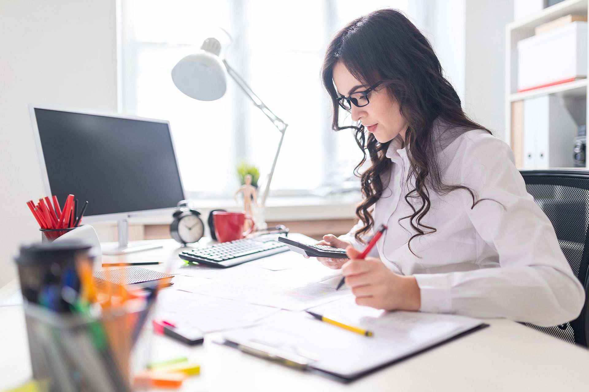 A Dreams Tax team member working with accounting documents in the office.