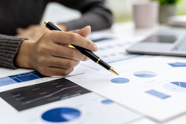 Business owner reviewing printed financial statements at a desk.