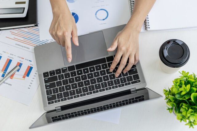 Businesswoman reviewing financial data on a laptop.
